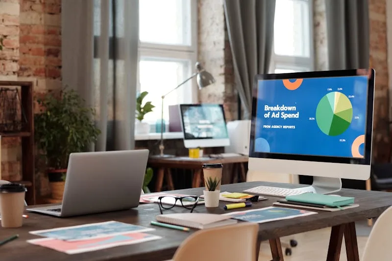 Büroarbeitsplatz mit Monitoren die Google Ads Dashboards und Kampagnen-Performance-Charts zeigen
